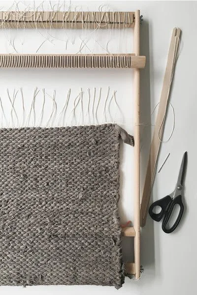 Unwinding the finished rag rug from the loom